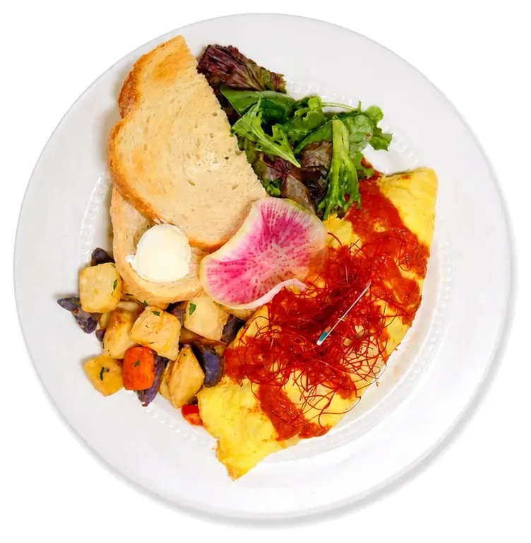 An omelette with toast, salad, breakfast potatoes and chilli sauce